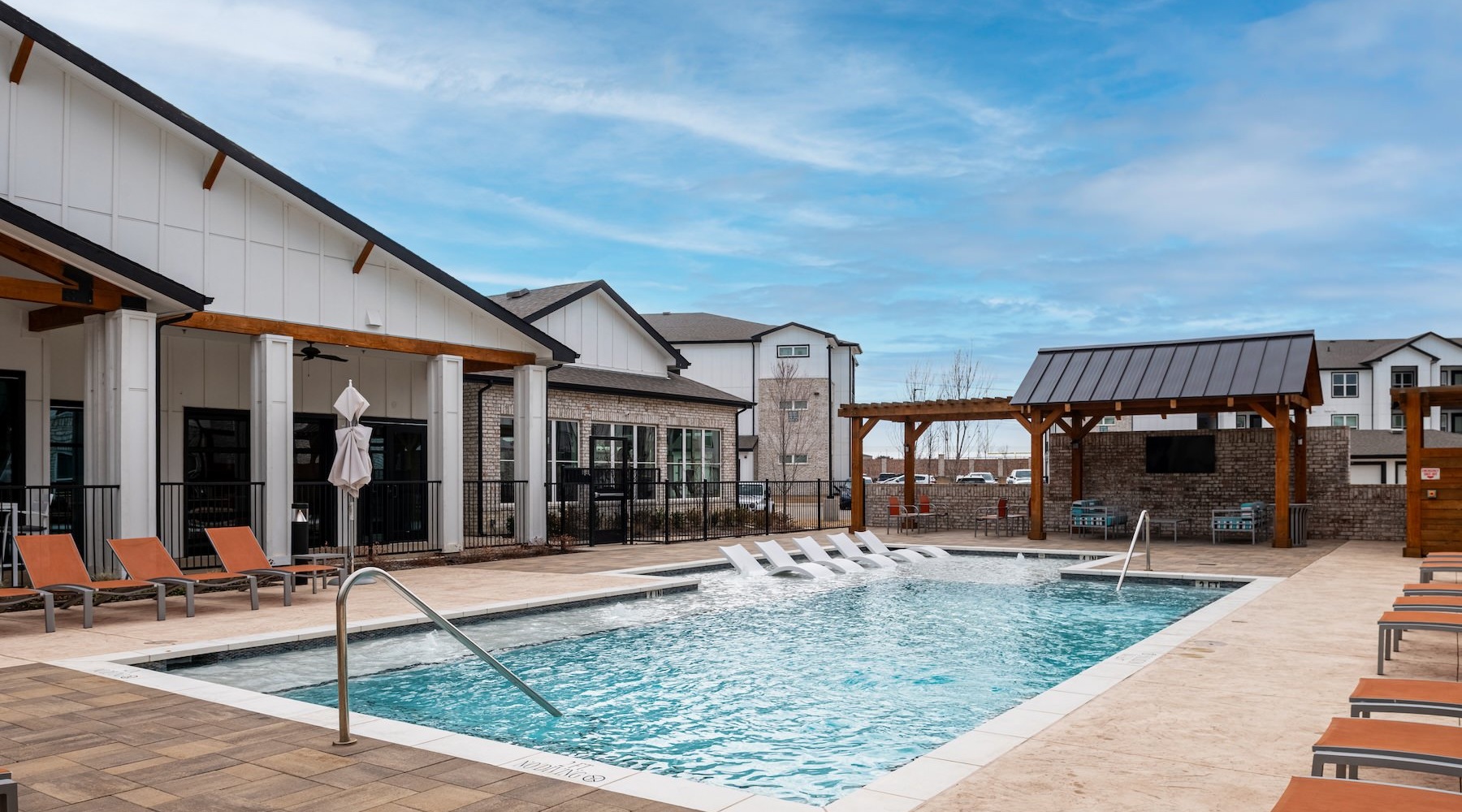 resort style pool with seating and a building behind it